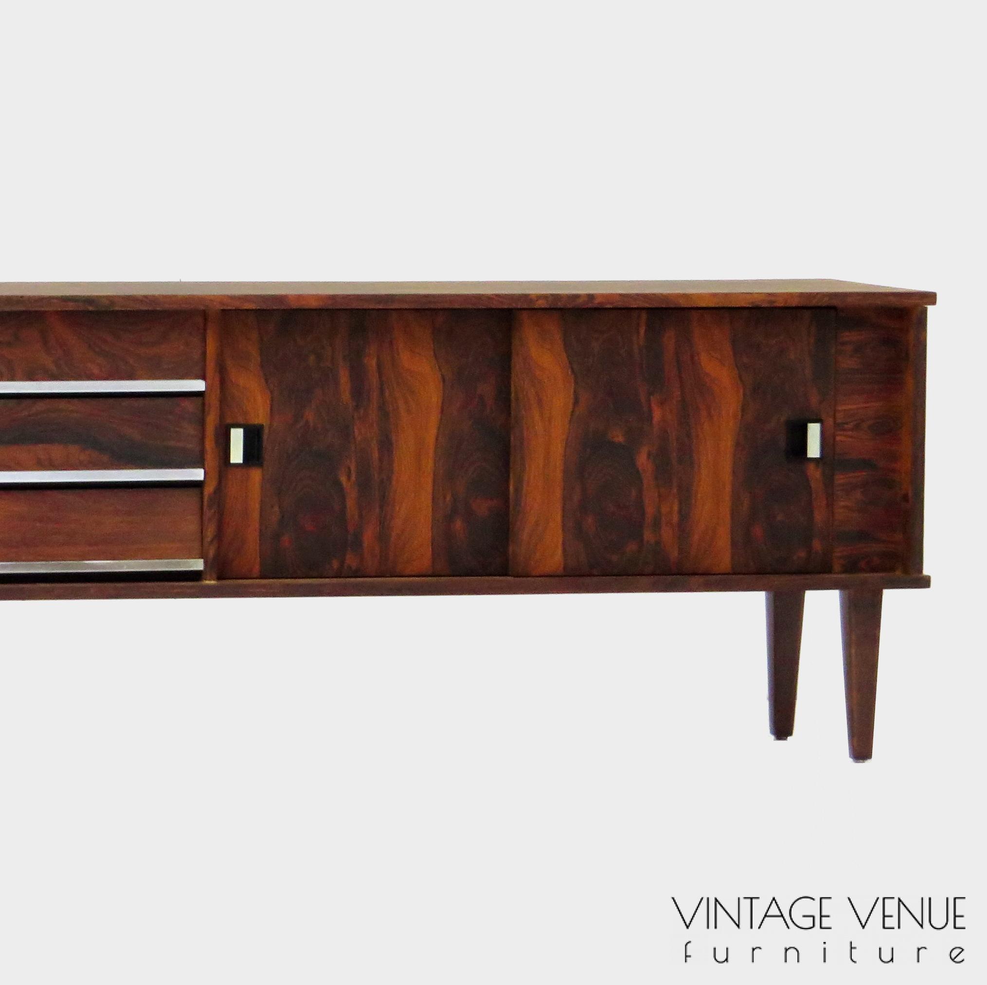 Vintage mid century modern low sideboard made of rosewood palisander, on 4 wooden legs with 2 sliding doors and 3 drawers with stylish handles & legs Period: 1960s Vintage retro lowboard dressoir tv-meubel van rosewood palissander met 2 schuifdeuren, 3 lades & stijlvolle handgrepen en pootjes, jaren 50 60 70