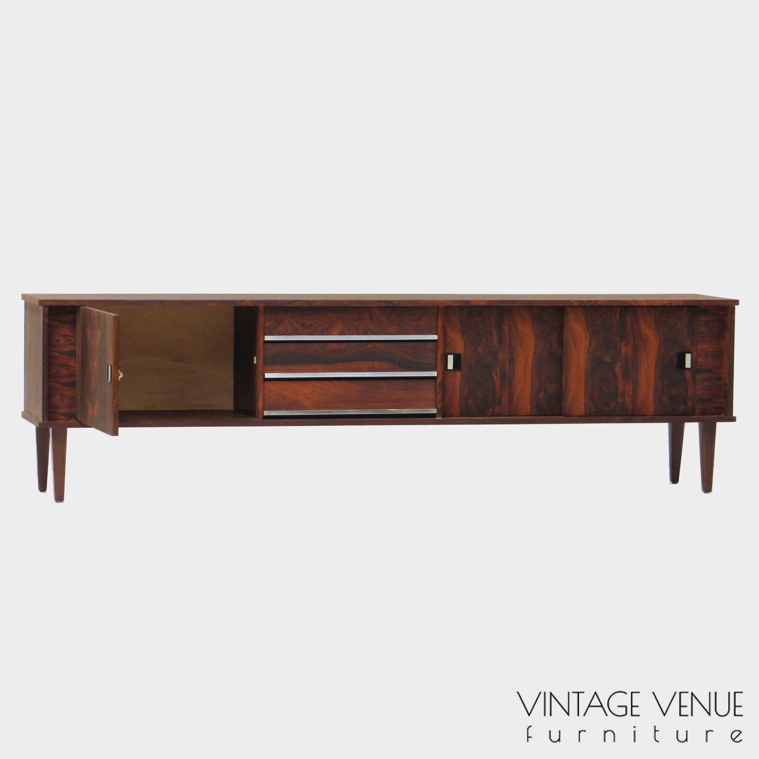 Vintage mid century modern low sideboard made of rosewood palisander, on 4 wooden legs with 2 sliding doors and 3 drawers with stylish handles & legs Period: 1960s Vintage retro lowboard dressoir tv-meubel van rosewood palissander met 2 schuifdeuren, 3 lades & stijlvolle handgrepen en pootjes, jaren 50 60 70