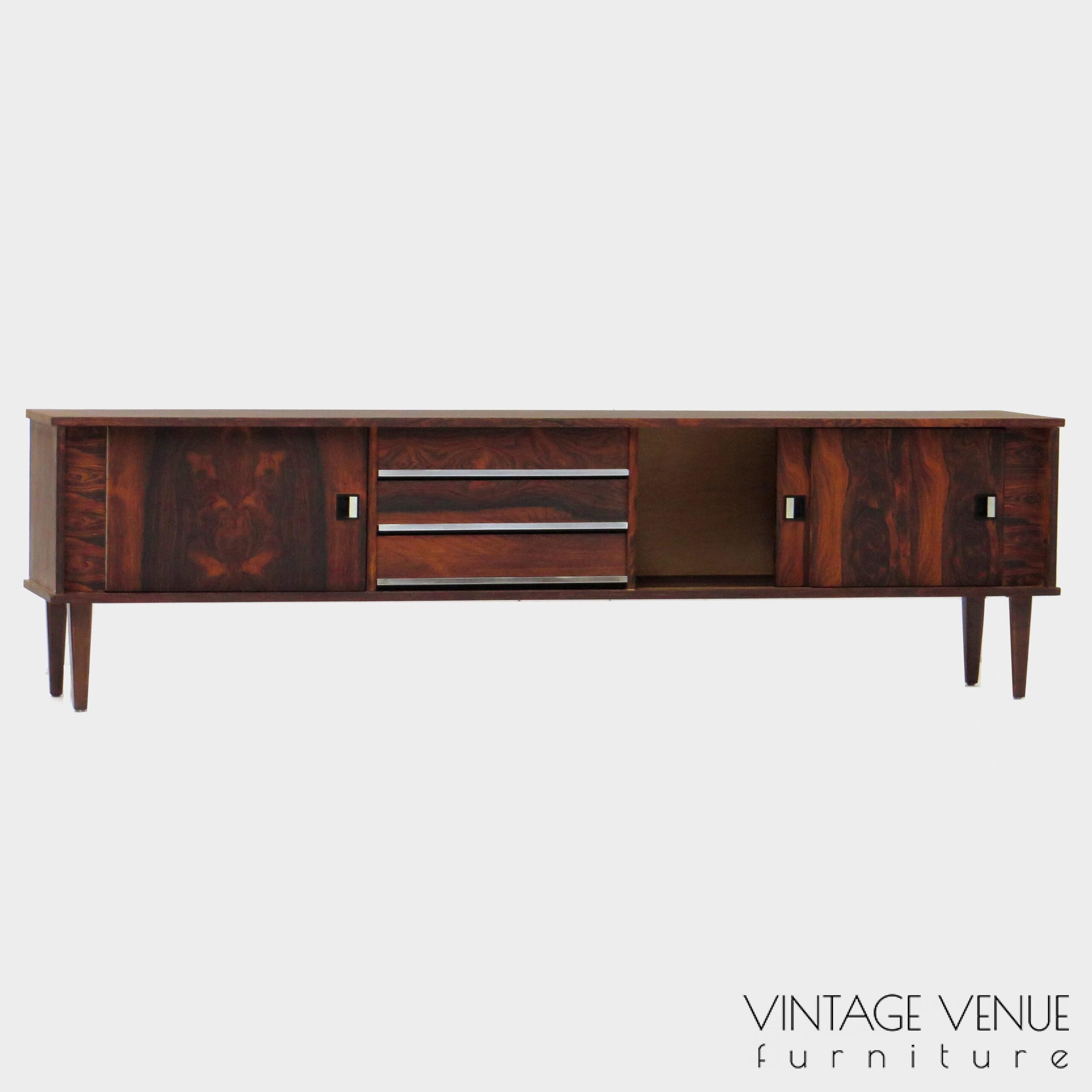Vintage mid century modern low sideboard made of rosewood palisander, on 4 wooden legs with 2 sliding doors and 3 drawers with stylish handles & legs Period: 1960s Vintage retro lowboard dressoir tv-meubel van rosewood palissander met 2 schuifdeuren, 3 lades & stijlvolle handgrepen en pootjes, jaren 50 60 70