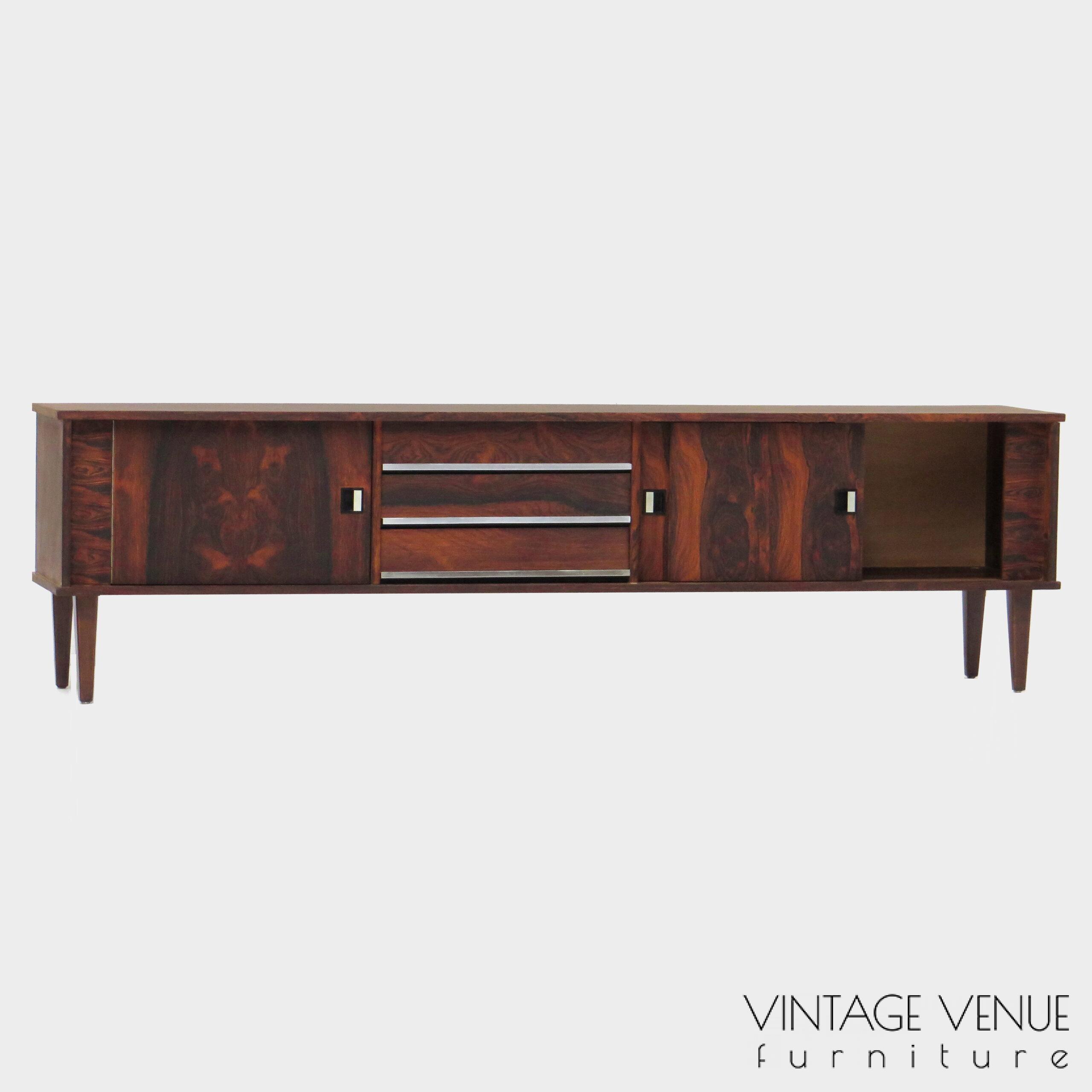 Vintage mid century modern low sideboard made of rosewood palisander, on 4 wooden legs with 2 sliding doors and 3 drawers with stylish handles & legs Period: 1960s Vintage retro lowboard dressoir tv-meubel van rosewood palissander met 2 schuifdeuren, 3 lades & stijlvolle handgrepen en pootjes, jaren 50 60 70