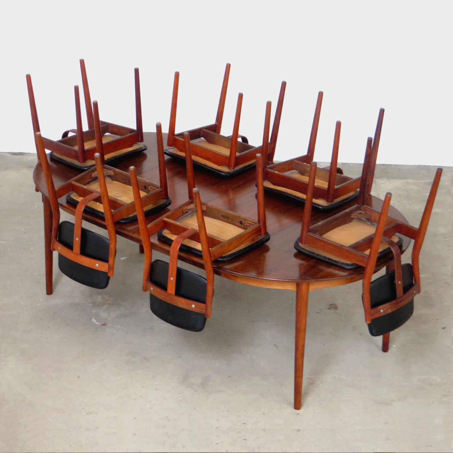 Foto van de tafel met de zes stoelen omgekeerd op het tafelblad